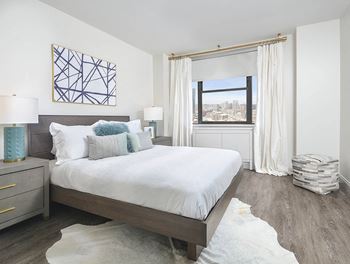 Modern bedroom with city view and white bedding